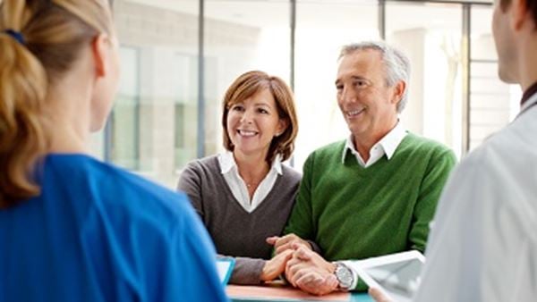 Image of two patients at hospital desk