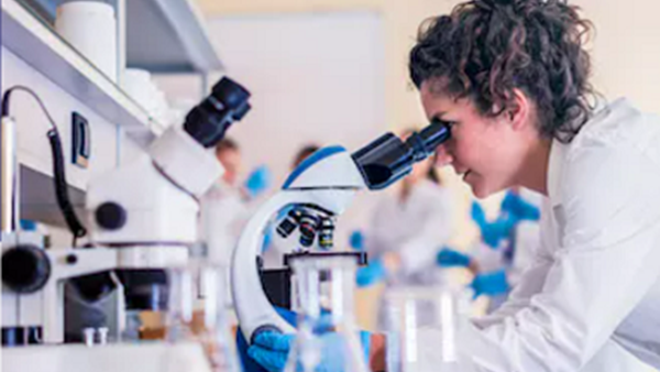 Image of woman looking through microscope